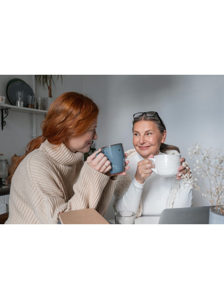 Two women talking at a table in a supportive conversation — you do not have to face this alone